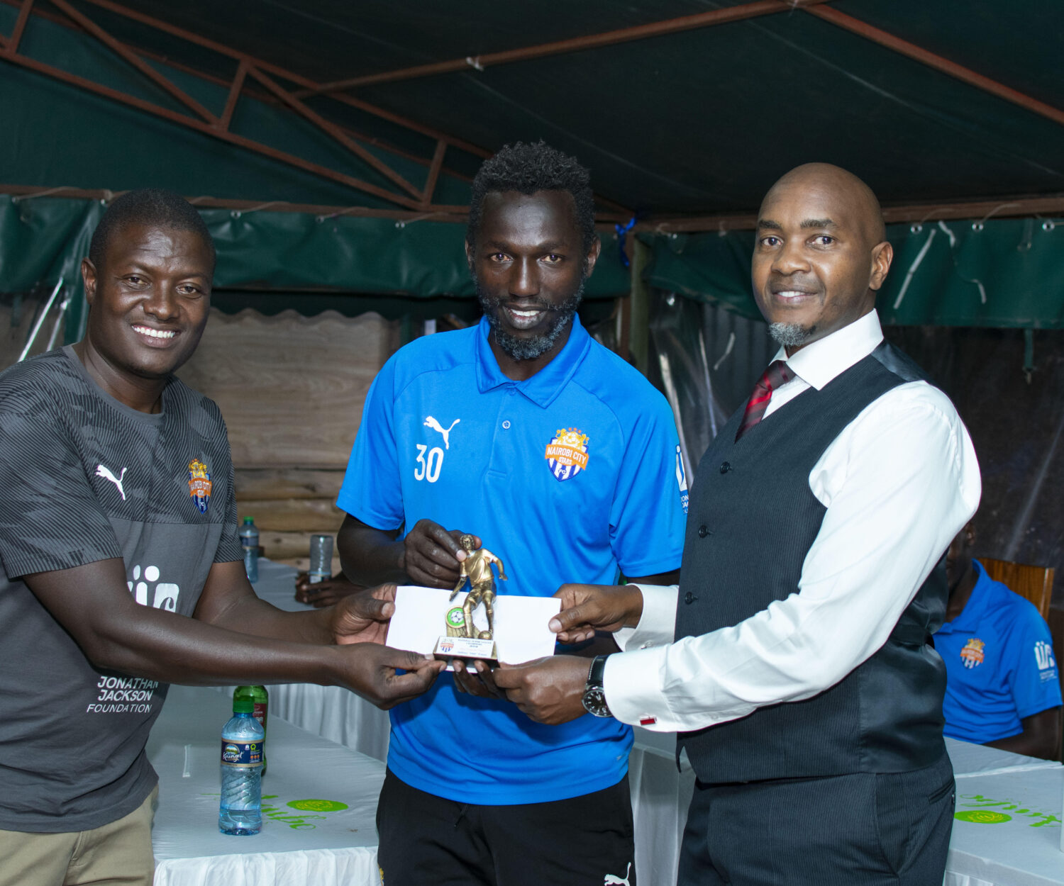 Anthony Muki Kimani is awarded by team coordinator Samson Otieno and CEO Patrick Korir on Mon 21 Dec 2020. He was named City Stars MVP for the ended 2019/20 that saw the team promoted back to the premier league