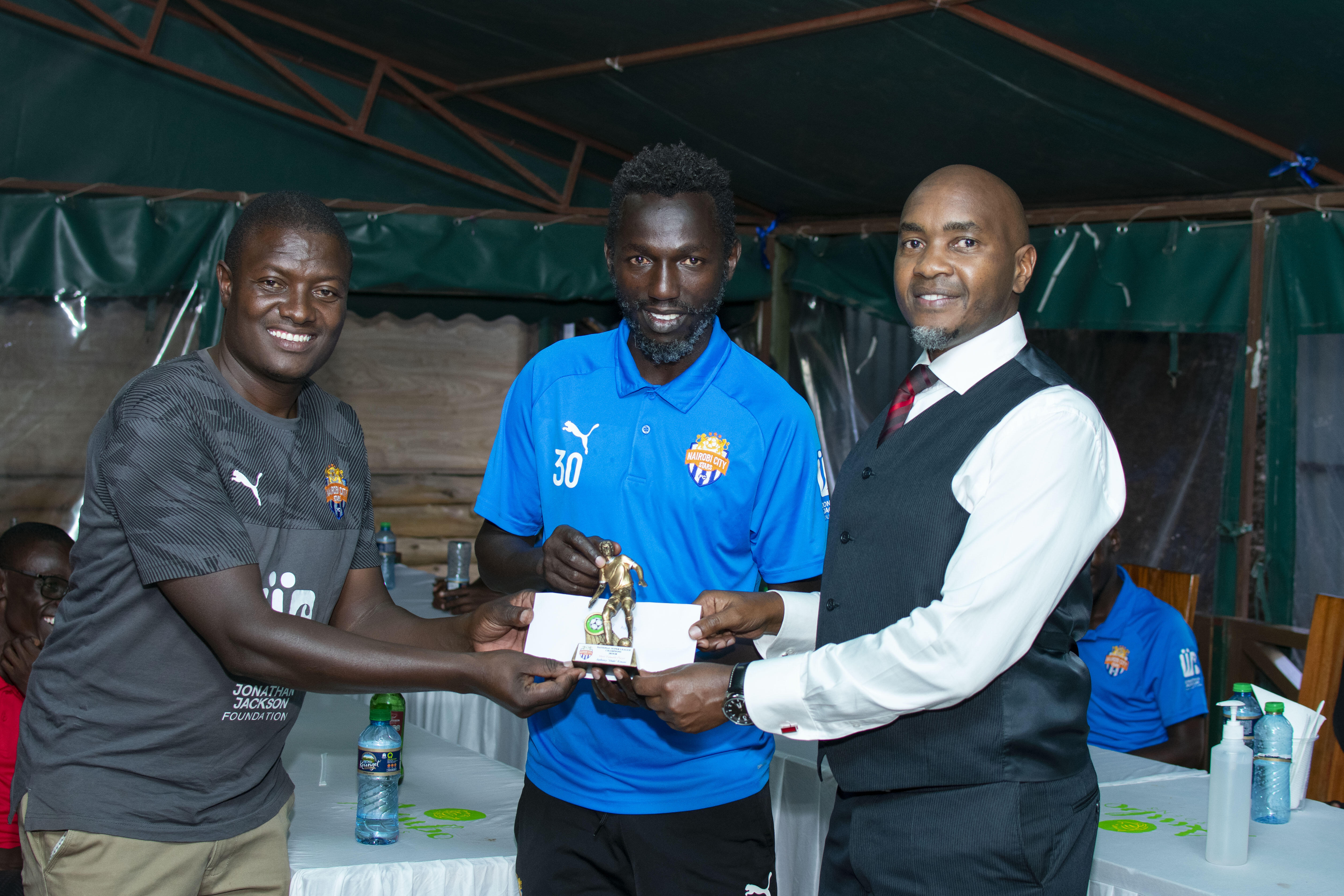Anthony Muki Kimani is awarded by team coordinator Samson Otieno and CEO Patrick Korir on Mon 21 Dec 2020. He was named City Stars MVP for the ended 2019/20 that saw the team promoted back to the premier league